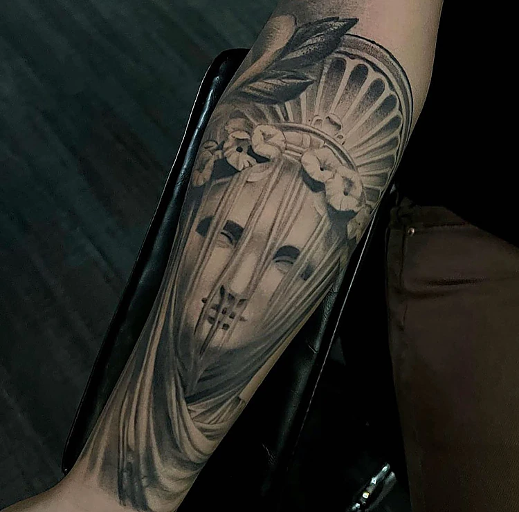 Estatua con velo y flores en realismo oscuro, en el antebrazo