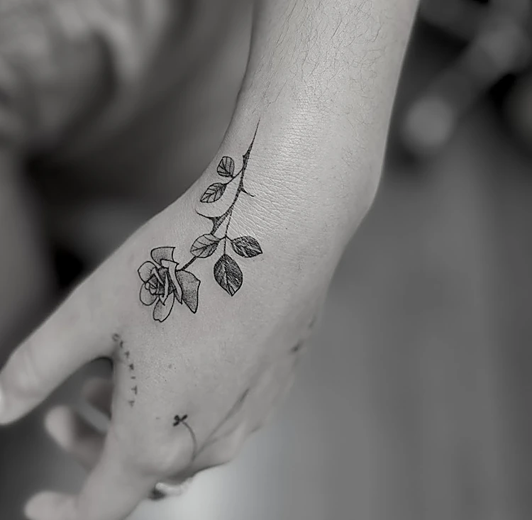 Rosa pequeña en línea fina en la mano